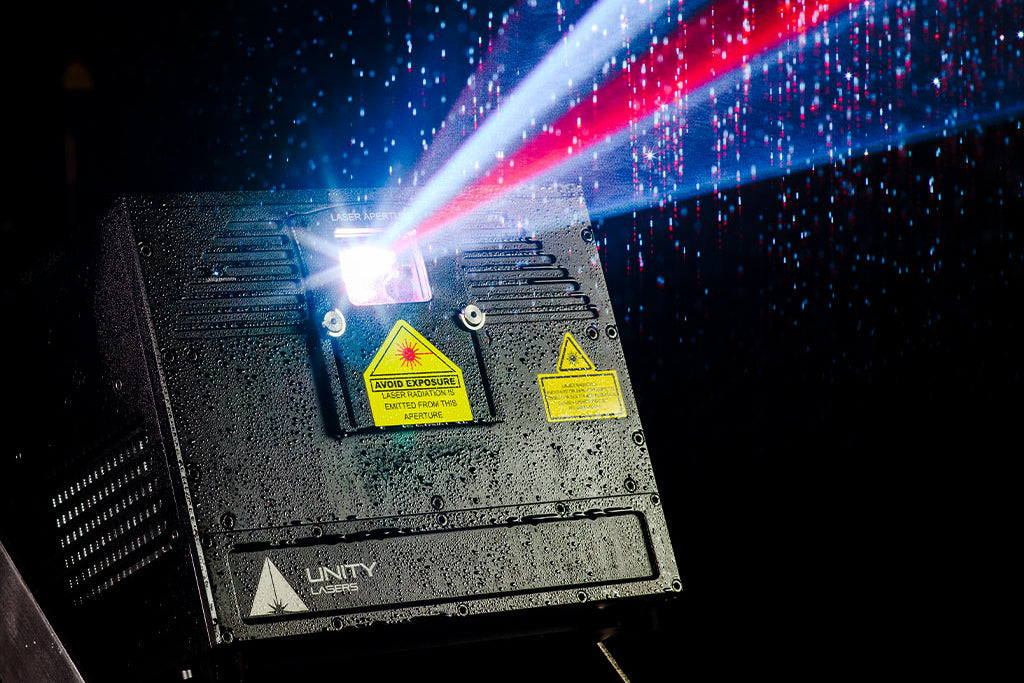 Laser shines bright with red and white beams through rain.